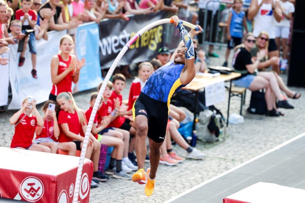 a man jumping over a pole